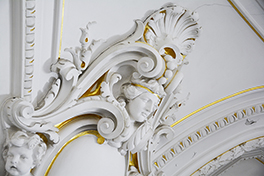 Hauptgebäude/Aula/Stuckatur weiss goldener Kopf/Seitenaufnahme