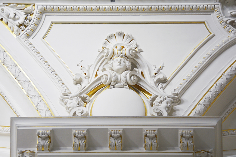 Hauptgebäude/Aula/Stuckatur weiss goldener Kopf