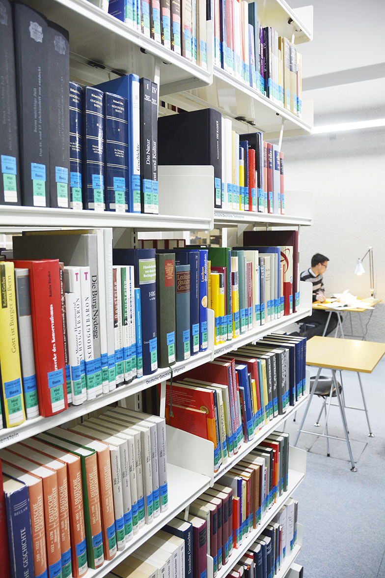 Basisbibliothek Unitobler/Innenansicht/Bücherregal/Student am Lernen