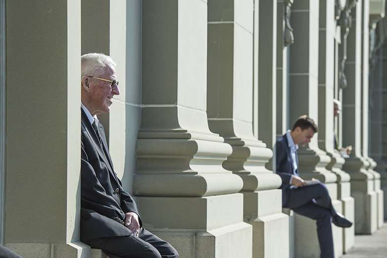 Anlass/Alumni Event/zwei Männer sitzen draussen am Gebäude/Sonnig